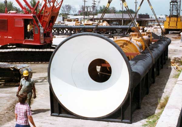 A hammer package being shipped from the Port of Palm Beach. The stabbing bell makes it easier for the crane operator to guide the pile to the pipe cap. They're faint, but one can see the concentric rings of the adjustable bell; these could be removed or added back for different sizes of pipe. The black with white bell was the standard Vulcan colour scheme for its leaders, although the action shots make it clear that paint didn't last too long offshore. Shipping the hammer in the leaders was a sensible option, especially since deck cargo is charged both by weight and volume. Note yet another package in the background.
