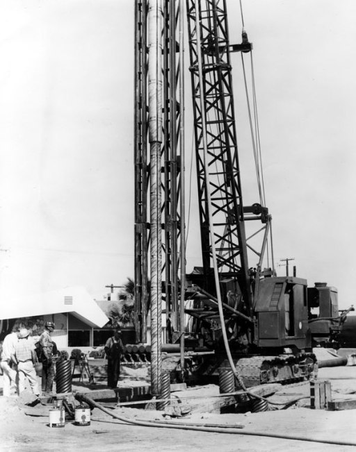 The Vulcan Expanding Mandrel, probably having just been removed from the shell pile it has just driven at a job in Indio, California, near Palm Springs. At the start of driving, the shell is hoisted into the leaders and the mandrel lifted above the head of the shell and inserted into the shell. In the event that the leaders weren't long enough for both mandrel and shell, a "doodle pipe" could be used. This is a pipe slightly larger than the shell's outside diameter, driven at one place on the jobsite and completely clear of internal soil. A shell would be first inserted into the doodle pipe, then the mandrel lowered into the shell and expanded, and finally the assembly would be lifted out of the doodle pipe and positioned for proper installation.